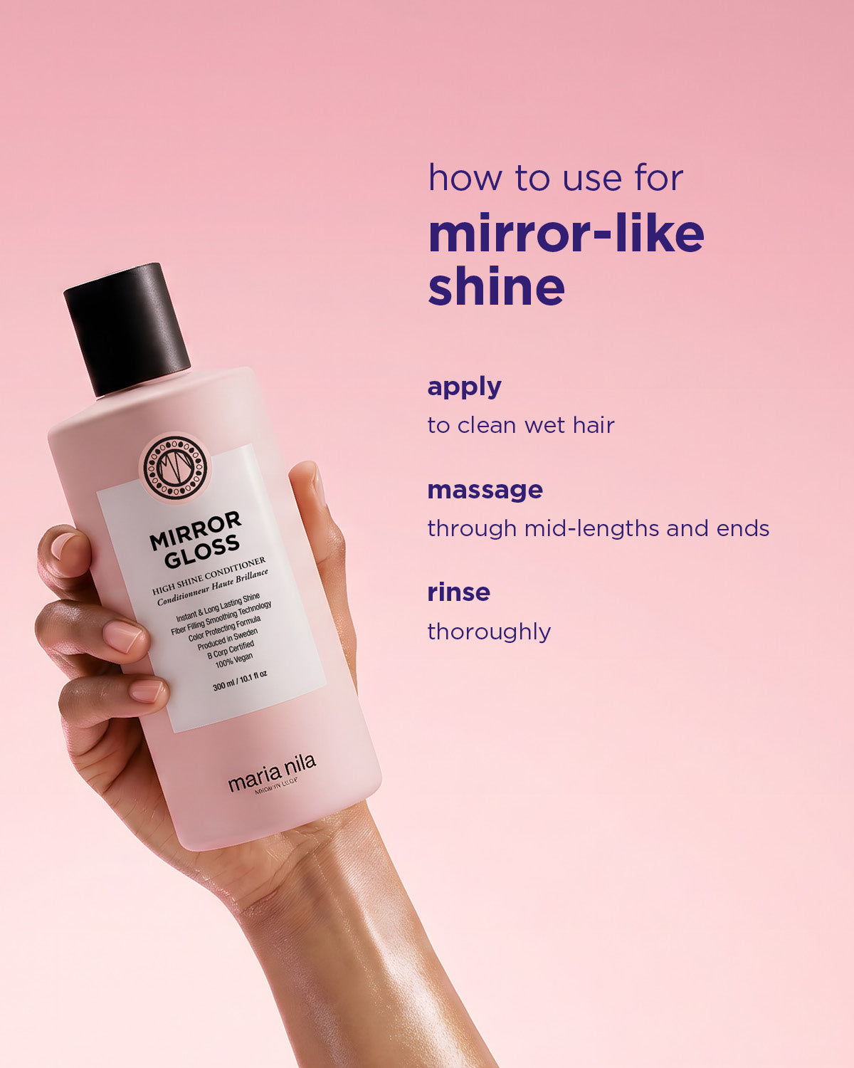 Hand holding a bottle of Maria Nila Mirror Gloss Conditioner with instructions on a pink background