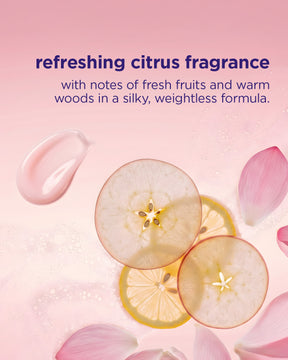 Product packaging with apple slices, lemon slices, and pink flowers on a pink background with text about refreshing citrus fragrance.